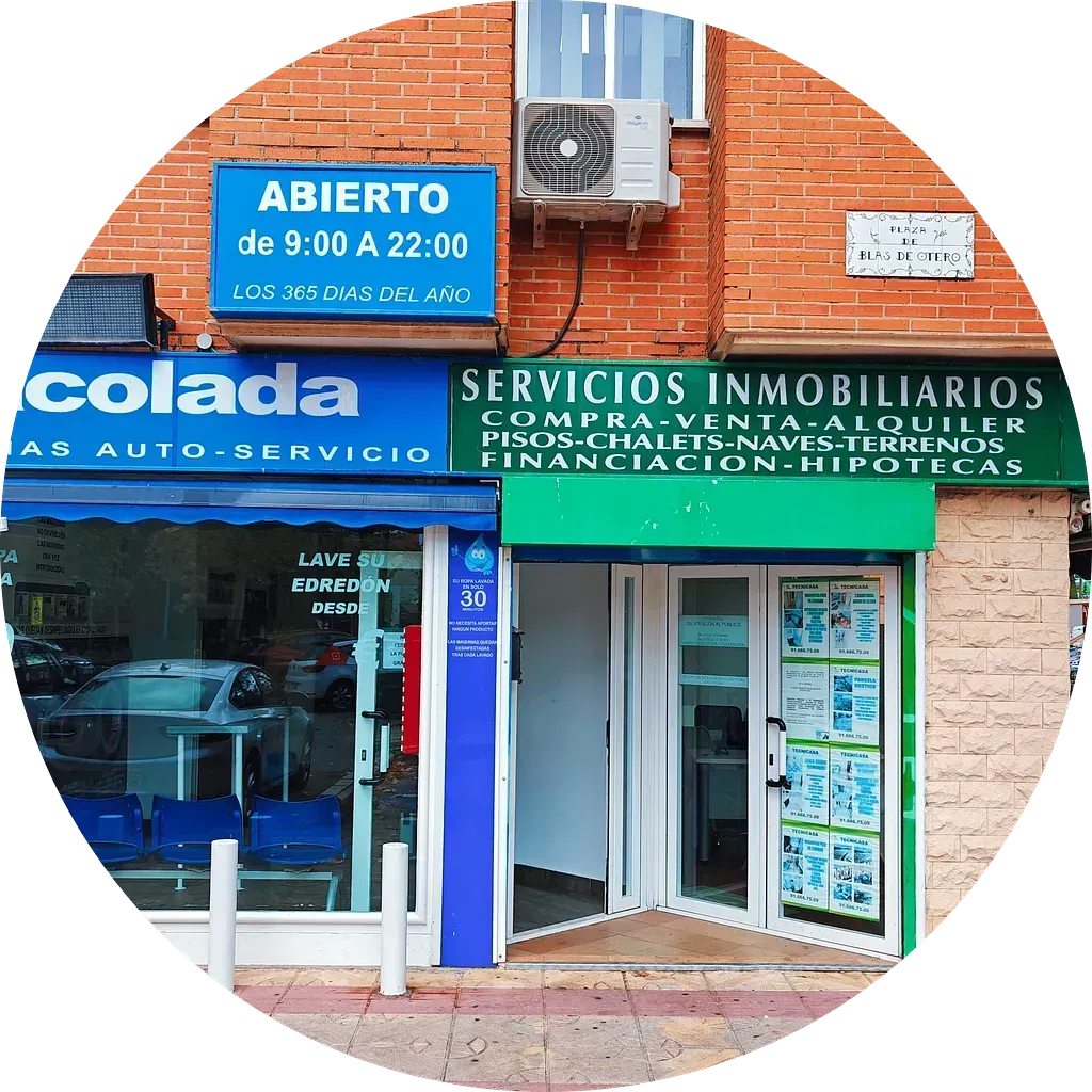 Un escaparate con un cartel que dice servicios inmobiliarios