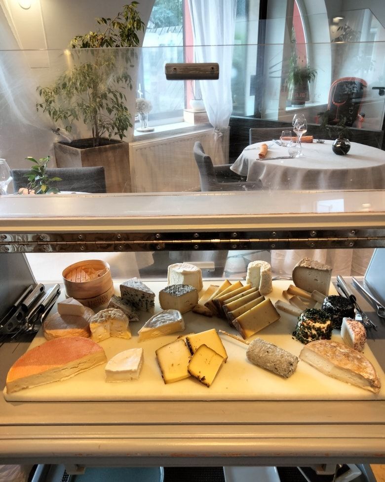 Une sélection variée de fromages artisanaux présentés sur une planche en bois.