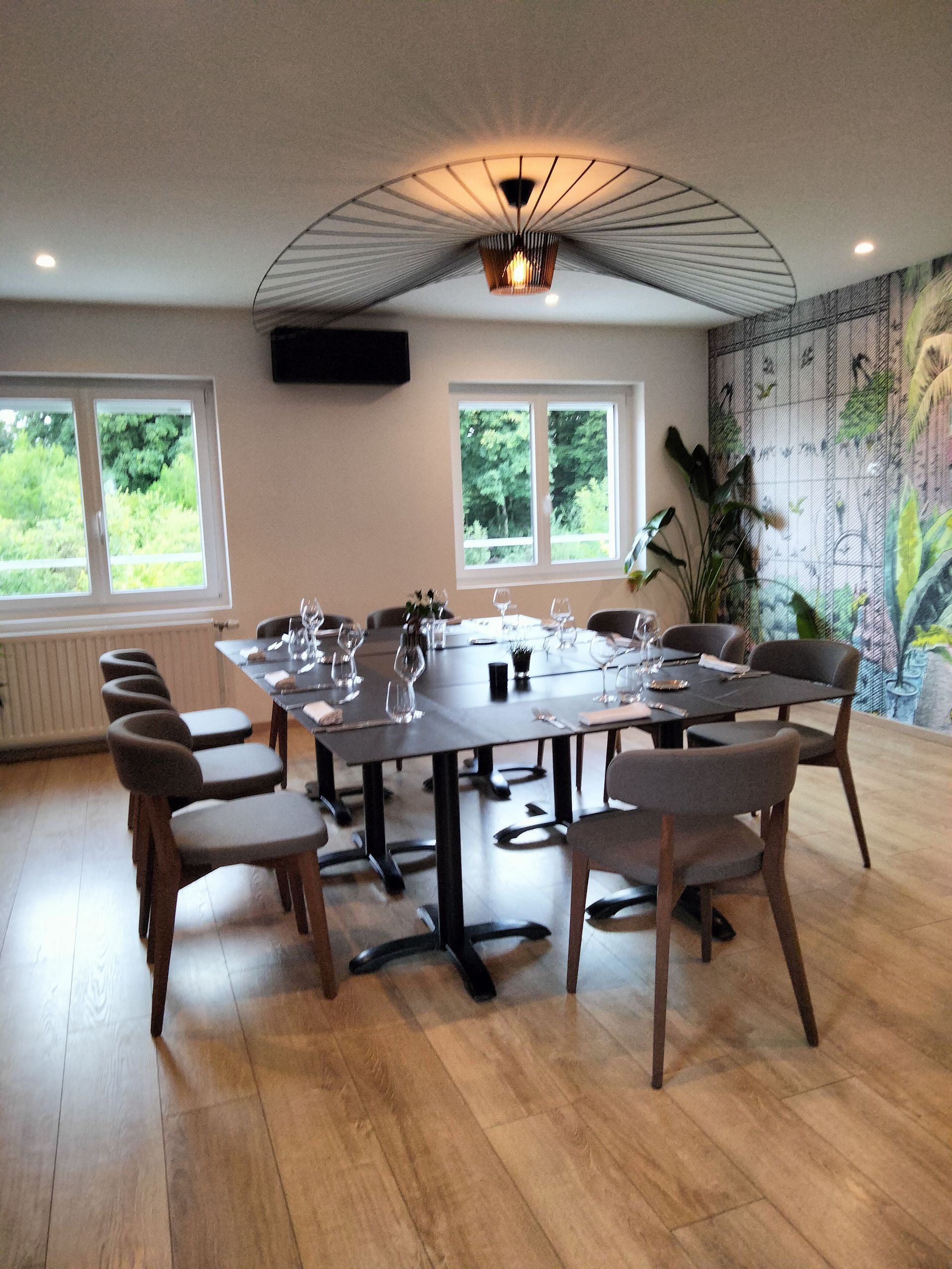 Un coin repas moderne avec une table carrée dressée pour huit personnes.
