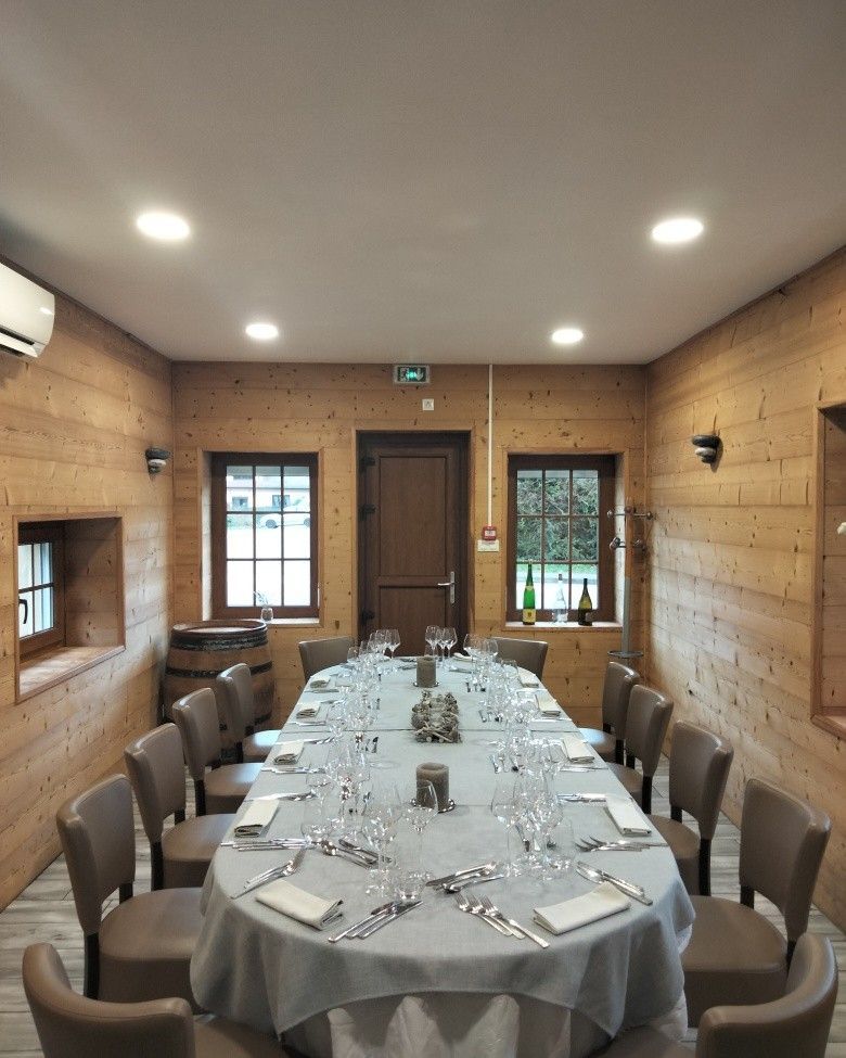 Une salle de réunion avec des tables noires, une fresque murale tropicale, de grands luminaires décoratifs.
