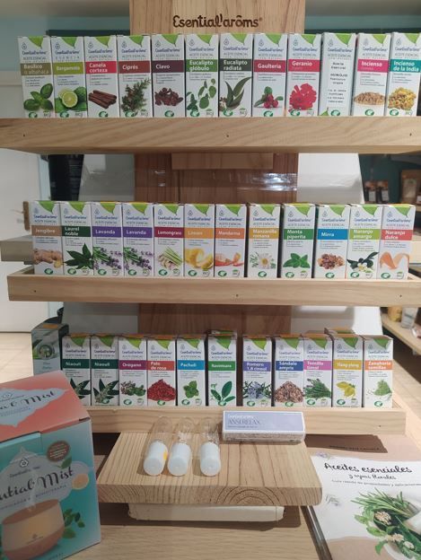 Ambientador con frascos de color ámbar, lavanda seca, hojas de eucalipto y una vela encendida sobre una bandeja de madera.