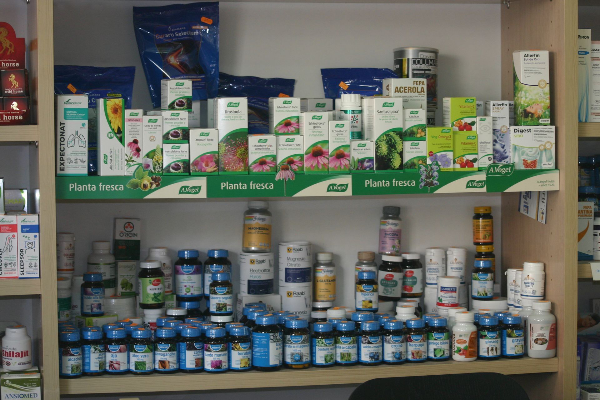 Estantes repletos de diversos suplementos para la salud y vitaminas en un pasillo de la tienda.