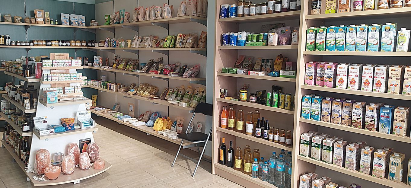 Estanterías repletas de productos envasados ​​y tarros en un pequeño pasillo de la tienda.