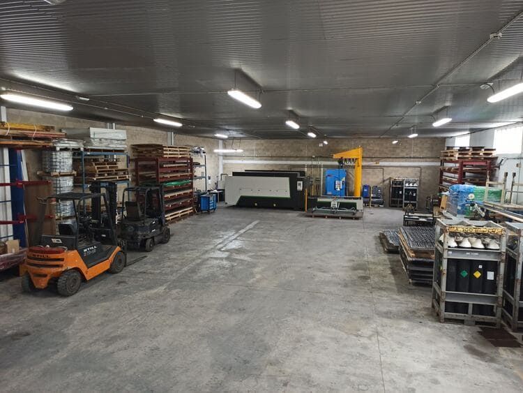 Un gran almacén con una carretilla elevadora en el medio.