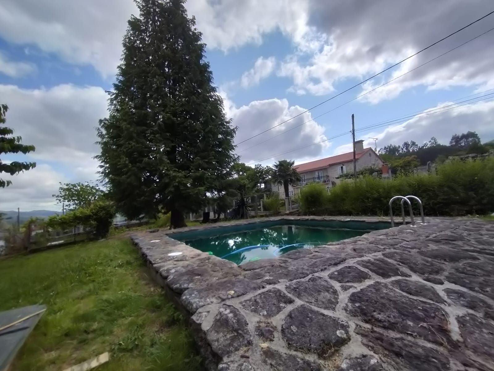 Una gran piscina está rodeada por un muro de piedra.