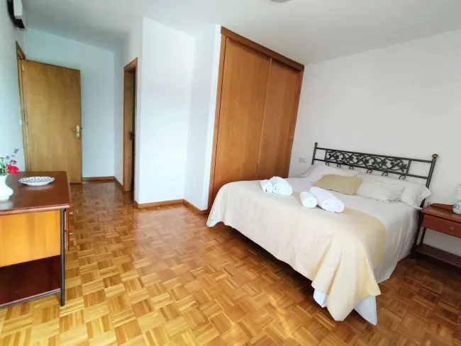 Un dormitorio con una cama king size y piso de madera.