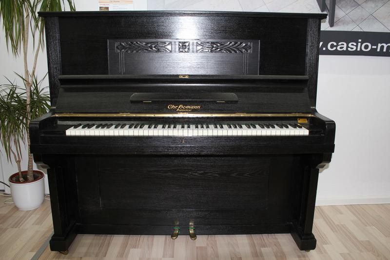 Schwarzes Klavier mit Tasten und Pedalen.
