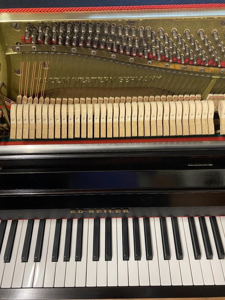 Klavierinnenraum mit Hämmern, Saiten und Tastatur sowie der Aufschrift „Schimmel Germany“.