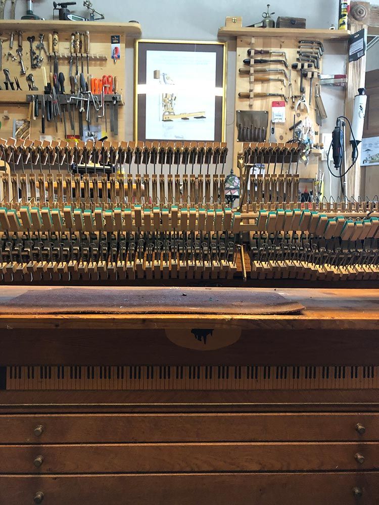 Die inneren Bauteile eines Klaviers, Werkzeuge an der Wand, Werkbank.