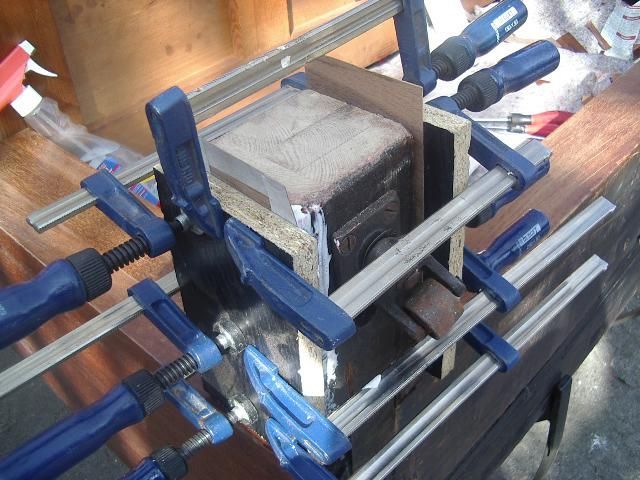 Eine mit mehreren blauen Klemmen zusammengehaltene Holzkiste; ein Holzbearbeitungsprojekt.