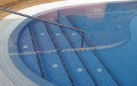 Una piscina con escaleras que conducen a ella y una barandilla.