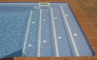 Una piscina con azulejos azules y rayas blancas en los escalones.