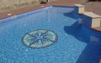 Una gran piscina con un mosaico en el medio.