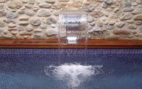 Una cascada sale del costado de una piscina.