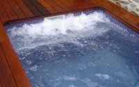 Un jacuzzi está situado encima de una plataforma de madera.