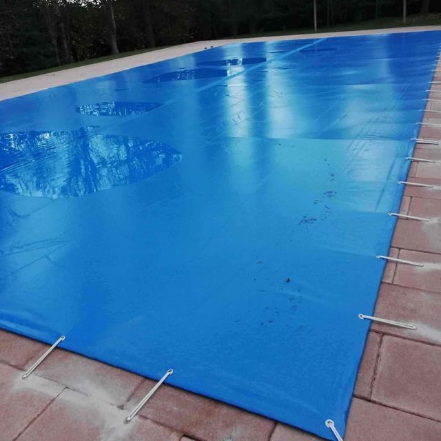 Una gran lona azul cubre una piscina.