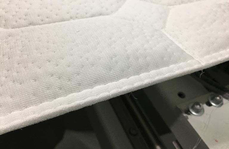 Eine Nahaufnahme eines Stücks Stoff auf einer Nähmaschine.