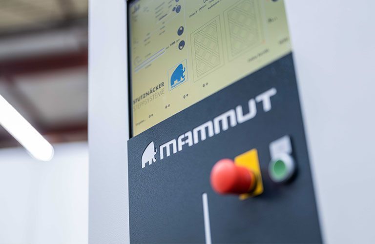 Eine Person arbeitet in einer Fabrik an einer Maschine.