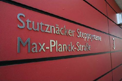 Eine rote Wand mit einem Schild mit der Aufschrift „Stutznacker Stepsysteme Max-Planck-Straße“
