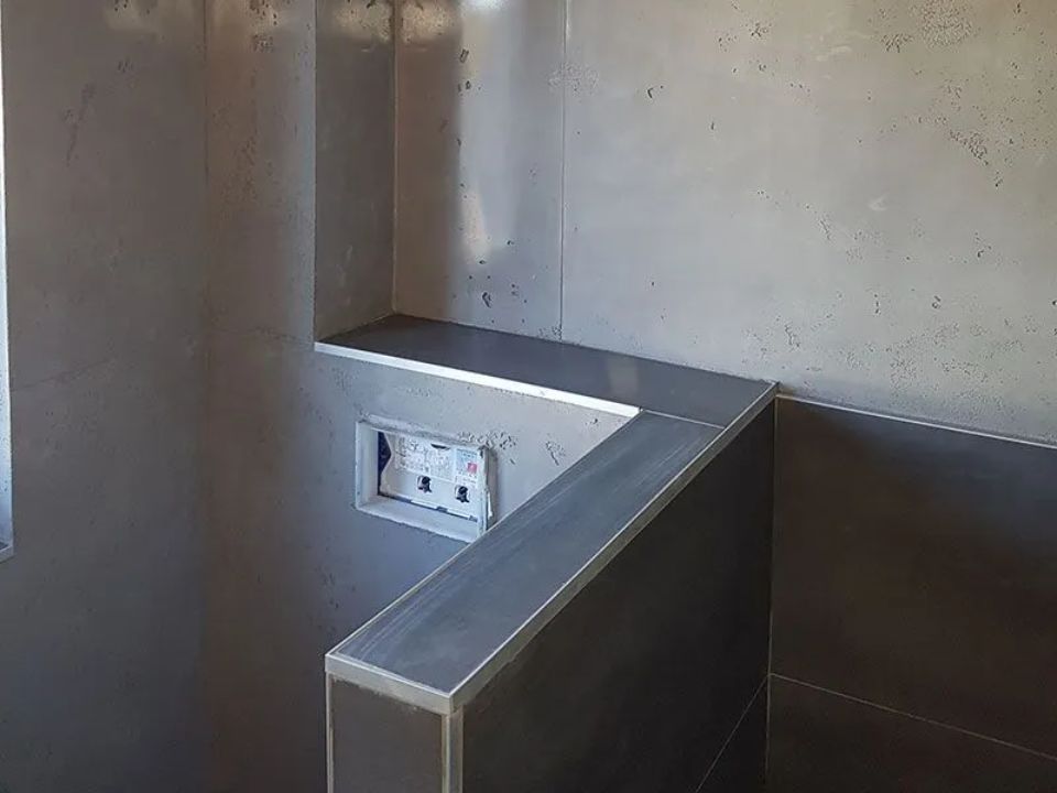 Betonoptikwand zur Abgrenzung in Badezimmer, ausgeführt durch ARAGON Projektentwicklung & Bauwerksanierung GmbH