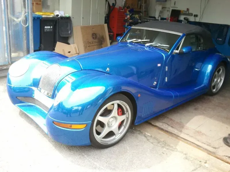 Blauer Sportwagen in einer Garage geparkt, schräg von vorn betrachtet