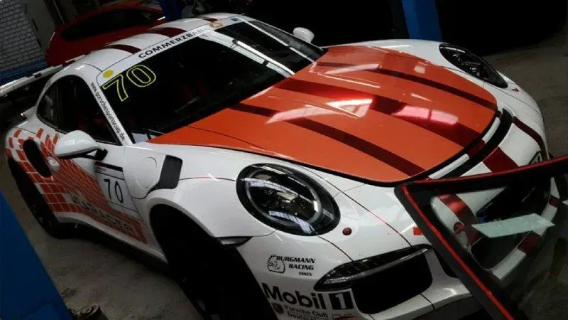 Rot-roßer Porsche-Rennwagen mit Mobil-1-Branding, von vorne links betrachtet.