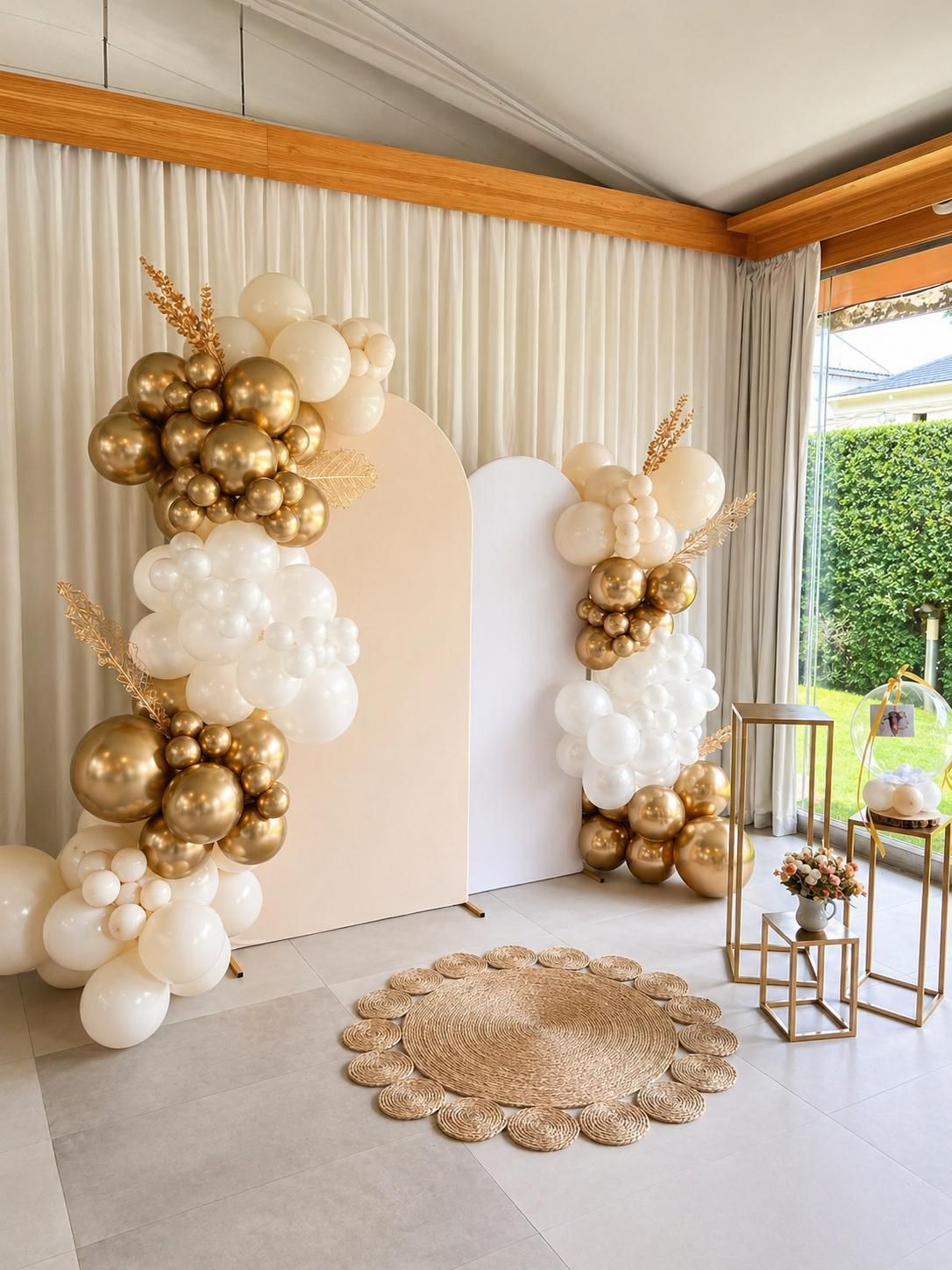 Fondo de arco de globos dorados y blancos con un panel festoneado y decoración dorada 