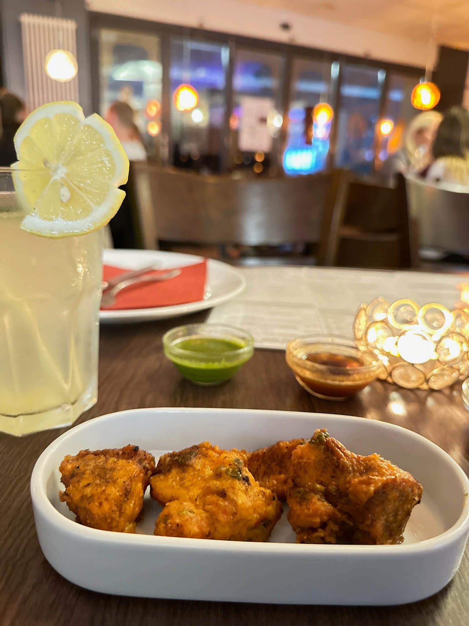 Auf einem Tisch steht ein Teller mit Essen neben einem Glas Limonade.