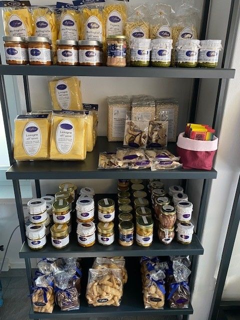 Scaffali pieni di alimenti confezionati e barattoli di vario genere in un negozio o in una dispensa.