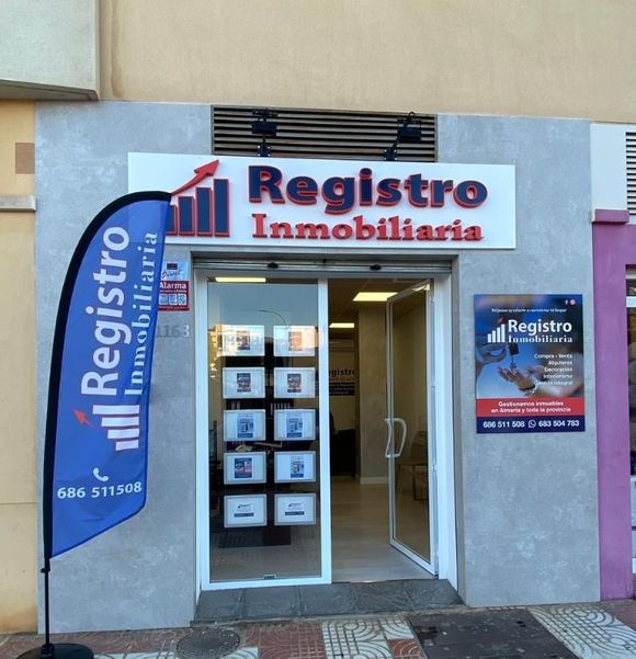 Exterior de oficina inmobiliaria con cartel: 