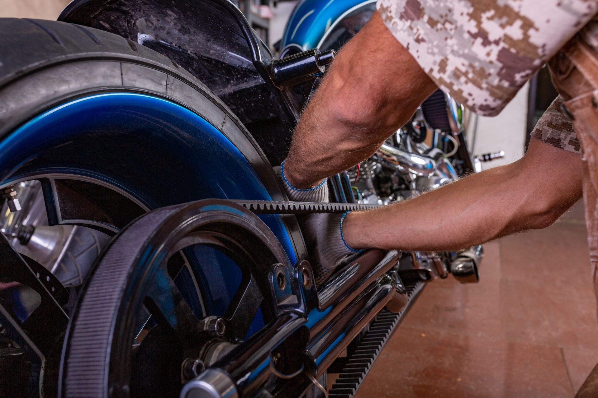 Un hombre está trabajando en una motocicleta azul en un garaje.