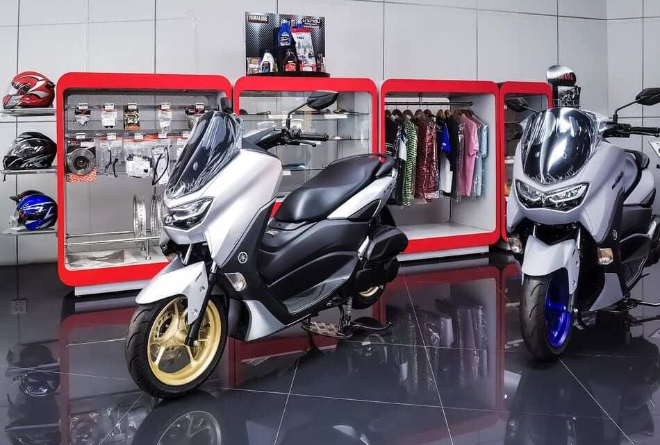 Dos motocicletas están estacionadas en una tienda una al lado de la otra.