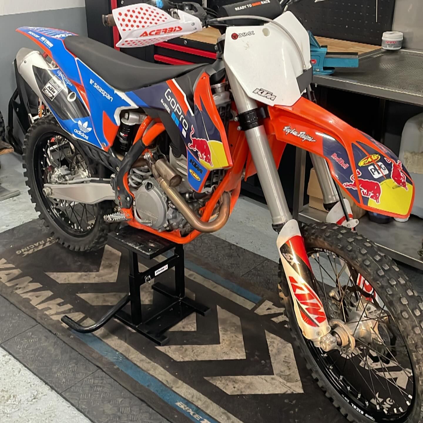 Una moto de cross está sobre una alfombra Yamaha