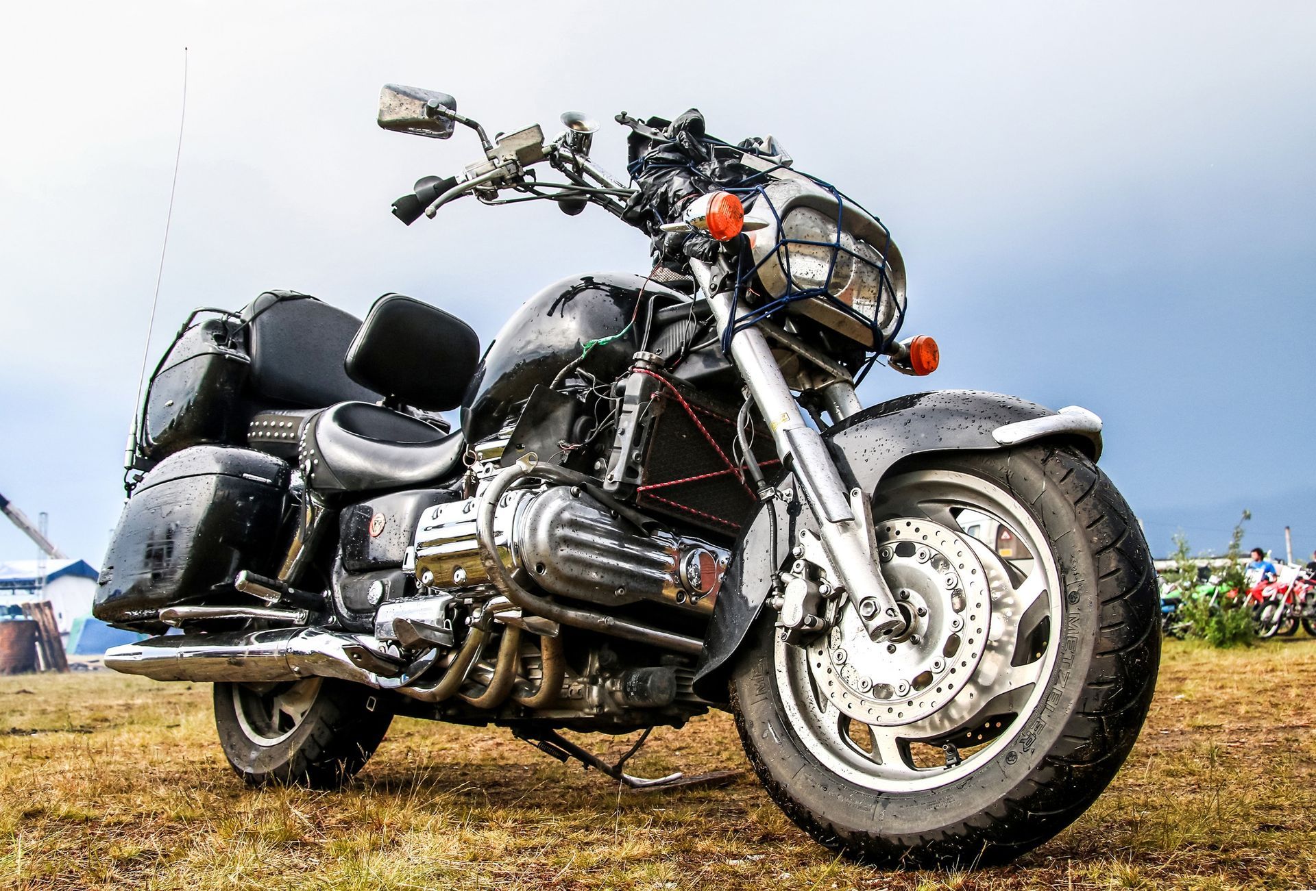 Una motocicleta está estacionada en el césped de un campo.