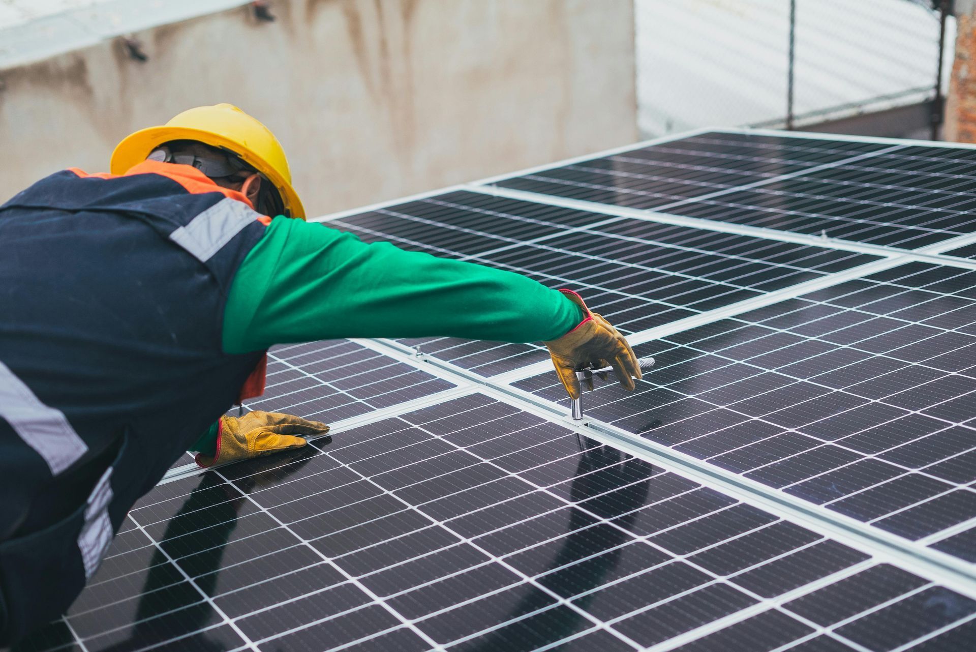 Trabajador de la construcción instalando paneles solares en un tejado.