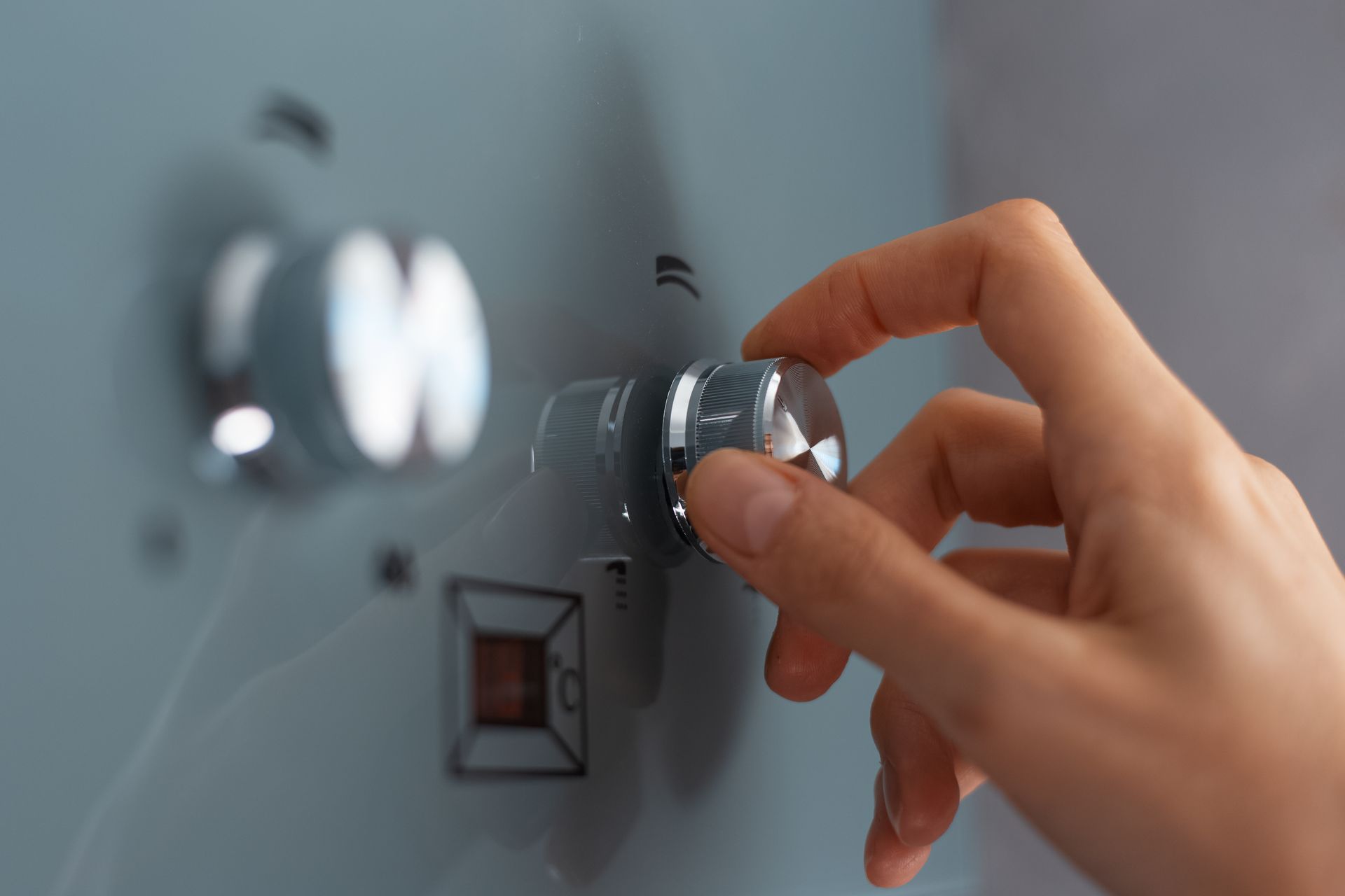 Une personne gère le thermostat de son chauffe-eau