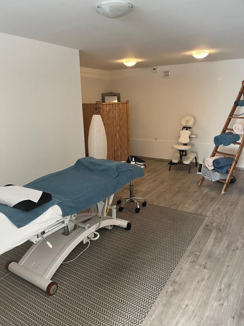 Il y a une table de massage au milieu de la pièce.