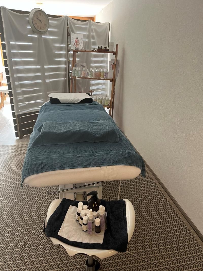 Une table de massage dans une pièce avec une horloge au mur.