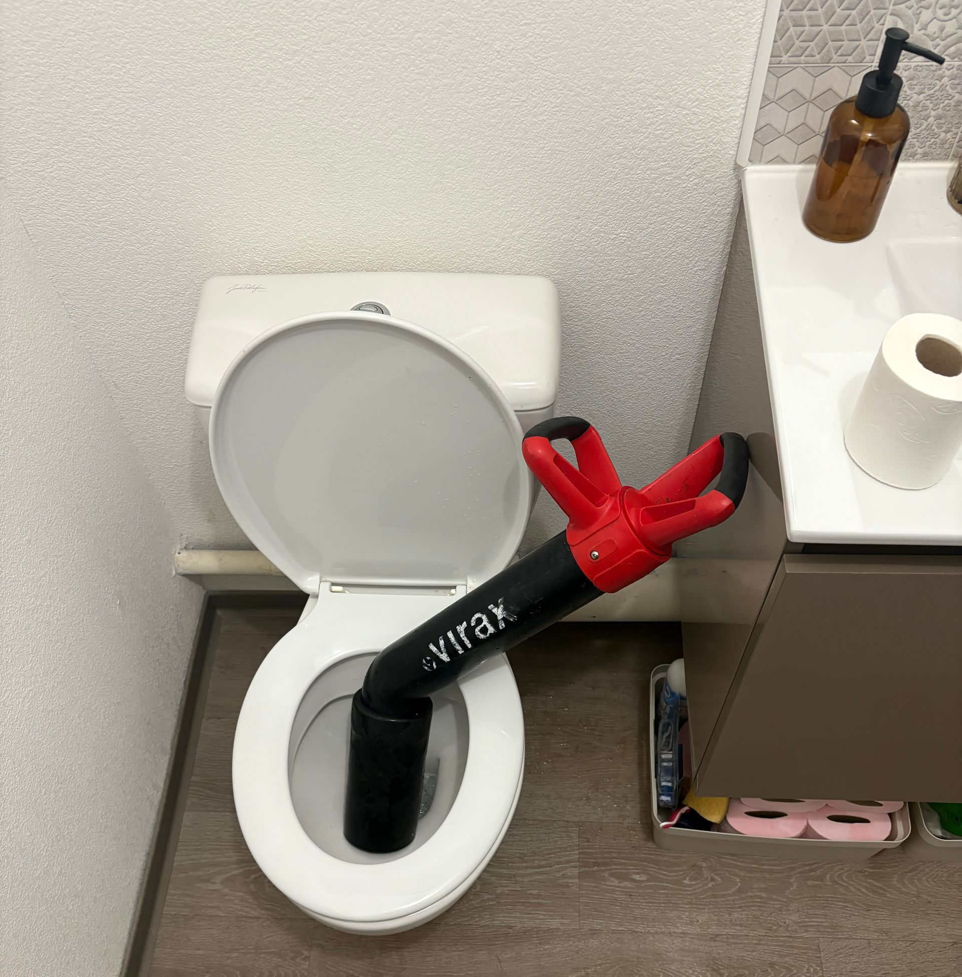 Des toilettes avec une ventouse à l'intérieur, dans une salle de bains.