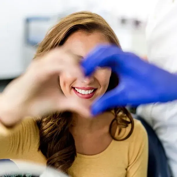 Una mujer está haciendo una forma de corazón con sus manos.