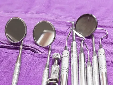 Un conjunto de instrumentos dentales sobre una toalla morada.