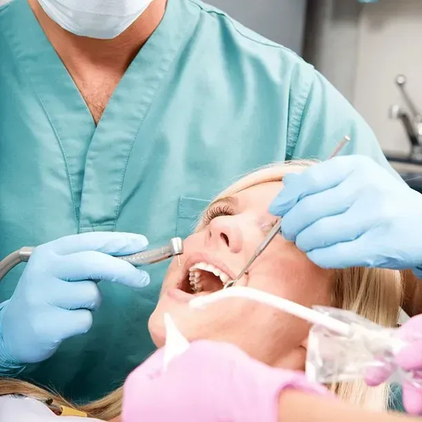 Una mujer se hace examinar los dientes por un dentista.