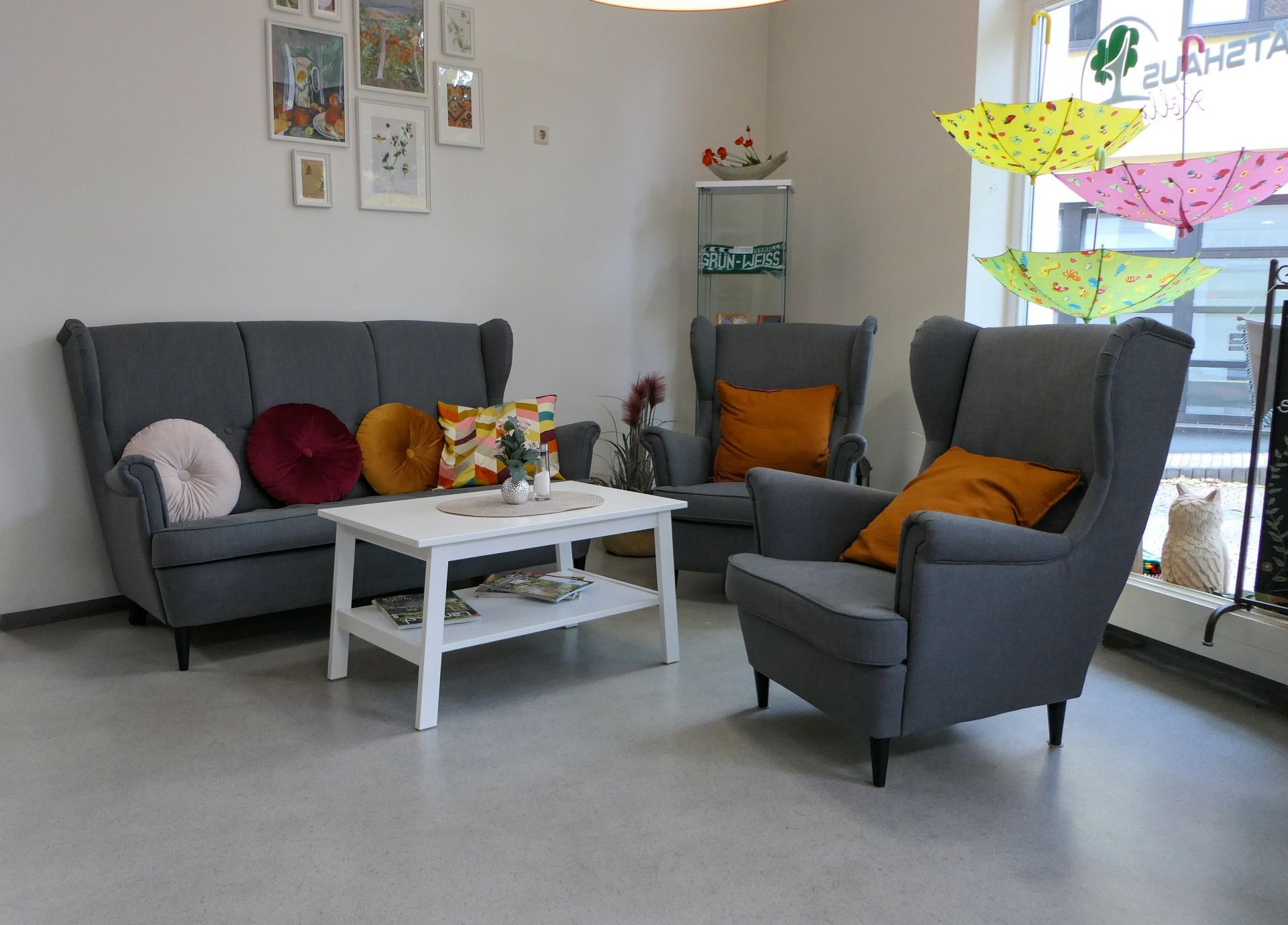 Kaffeestübchen: Dunkelgraue Couch und zwei Sessel mit braunen Kissen