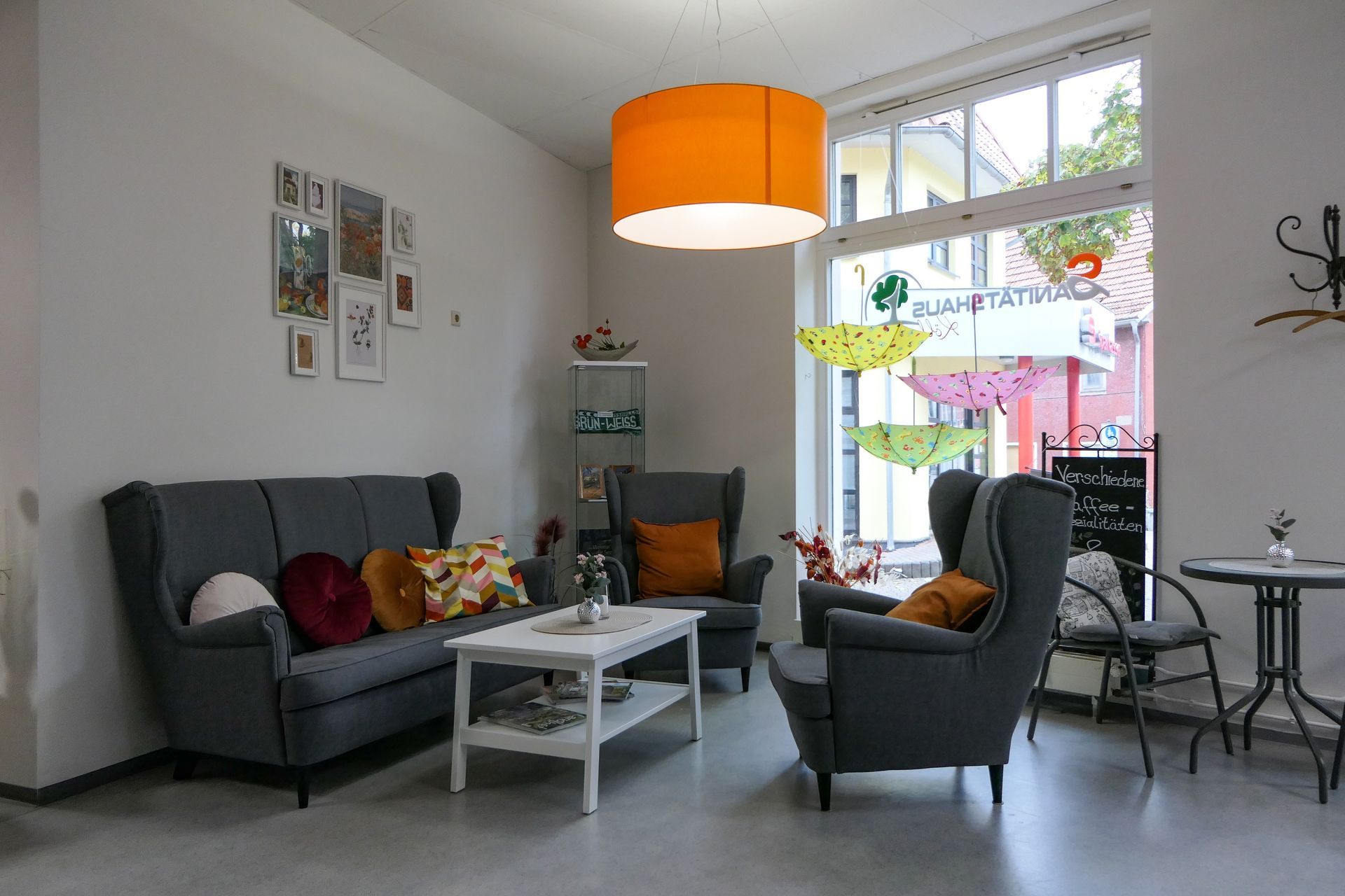 Kaffeestübchen: Dunkelgraue Couch und zwei Sessel mit braunen Kissen