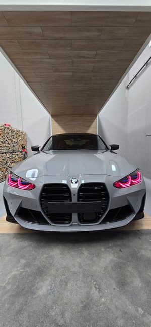 Un BMW M4 está aparcado en un garaje bajo un techo de madera.