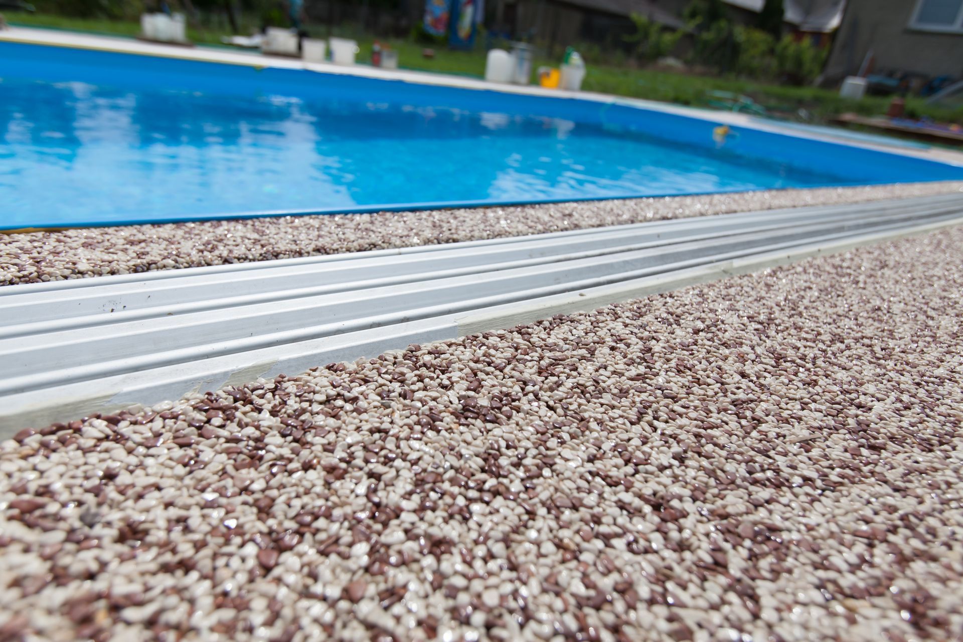 Terrasse en granulat de marbre pour une piscine avec abri