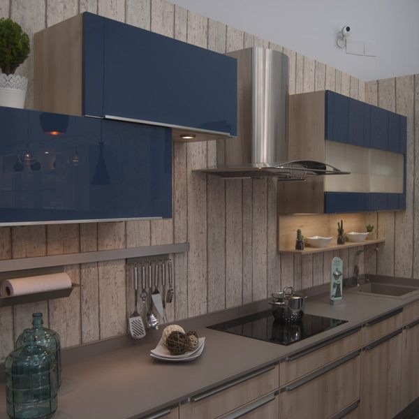 Cocina moderna con gabinetes azules y de madera, campana extractora de acero inoxidable