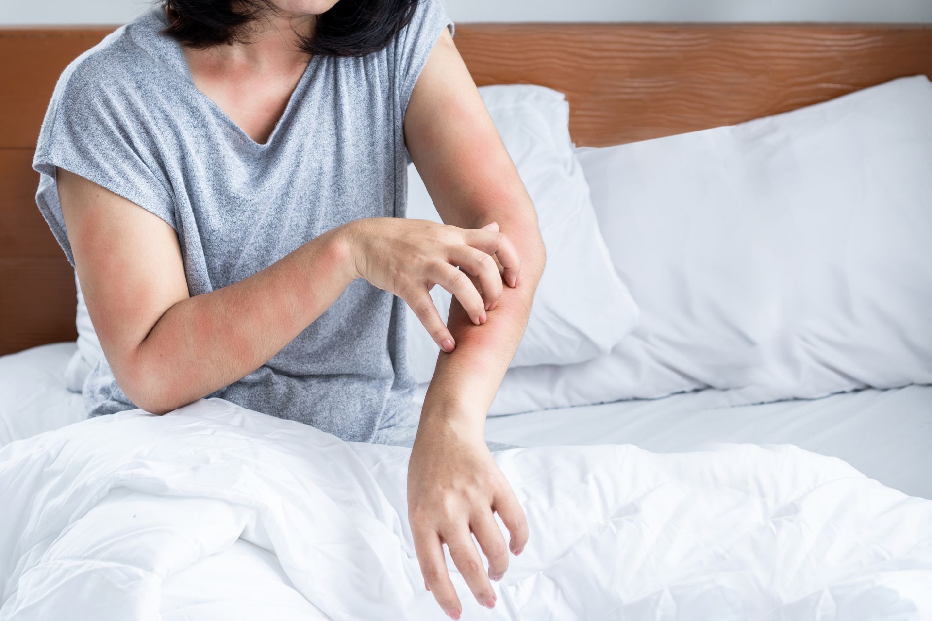 Une personne qui se gratte dans son lit.