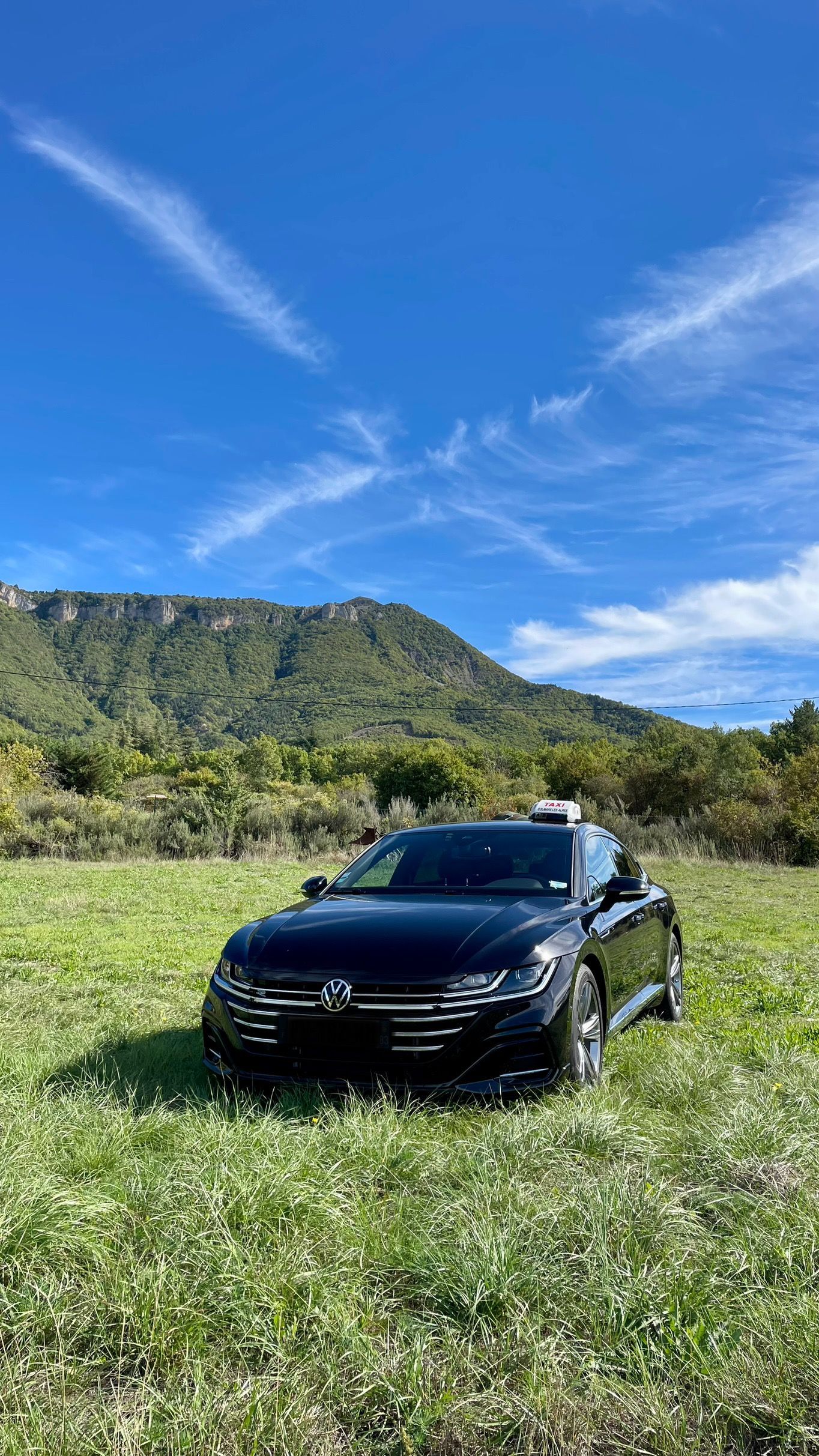 Taxi noir avec des montagnes en fond