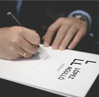 Una persona está escribiendo en un trozo de papel que dice ll lopez aguilo